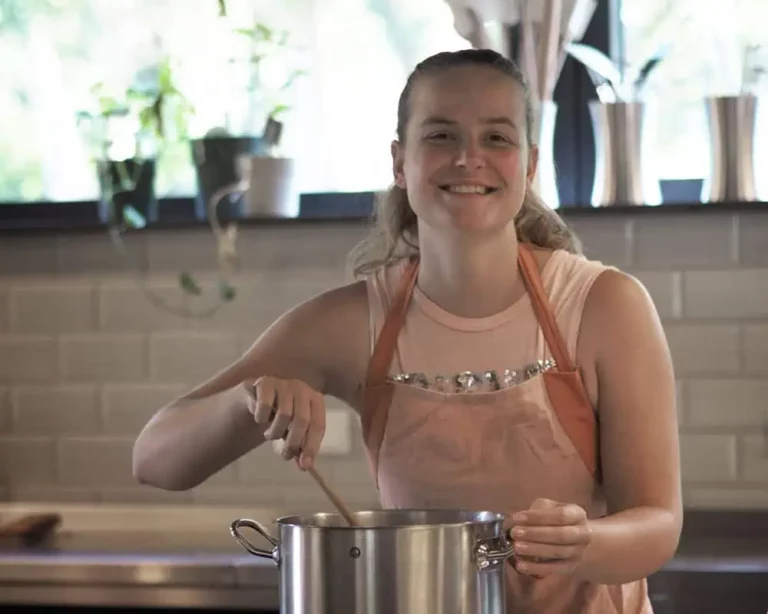 bezoeker lacht en roert in pan tijdens koken